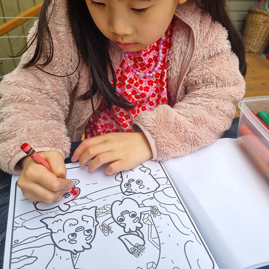 Child coloring a picture of Zip and the Tiny Sprouts with crayons on a coloring book