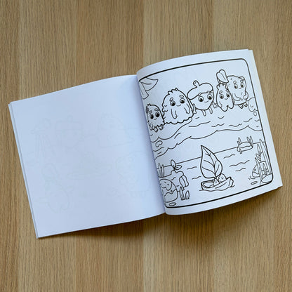 Open coloring book with a page of Zip and the Tiny Sprouts cartoon characters on a wooden surface